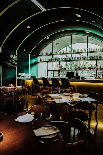 Salón principal de La Colonia con bóveda característica y barra iluminada